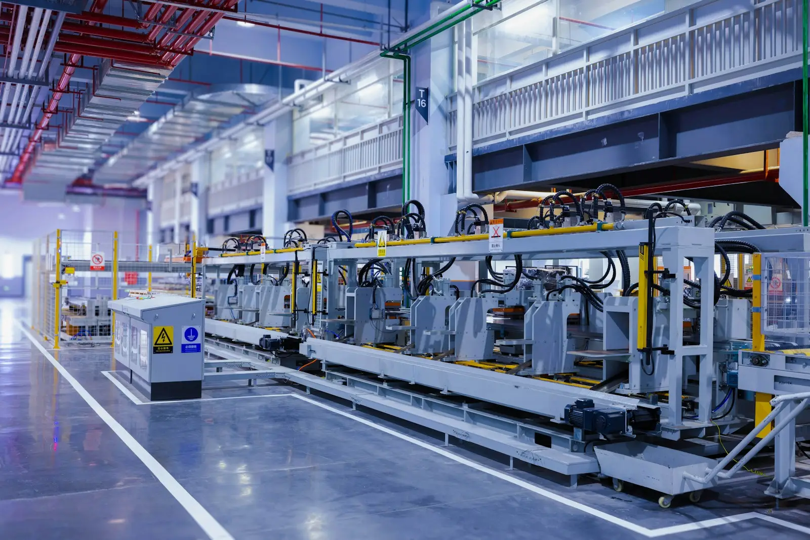 A production hall with machines running under overhead lighting