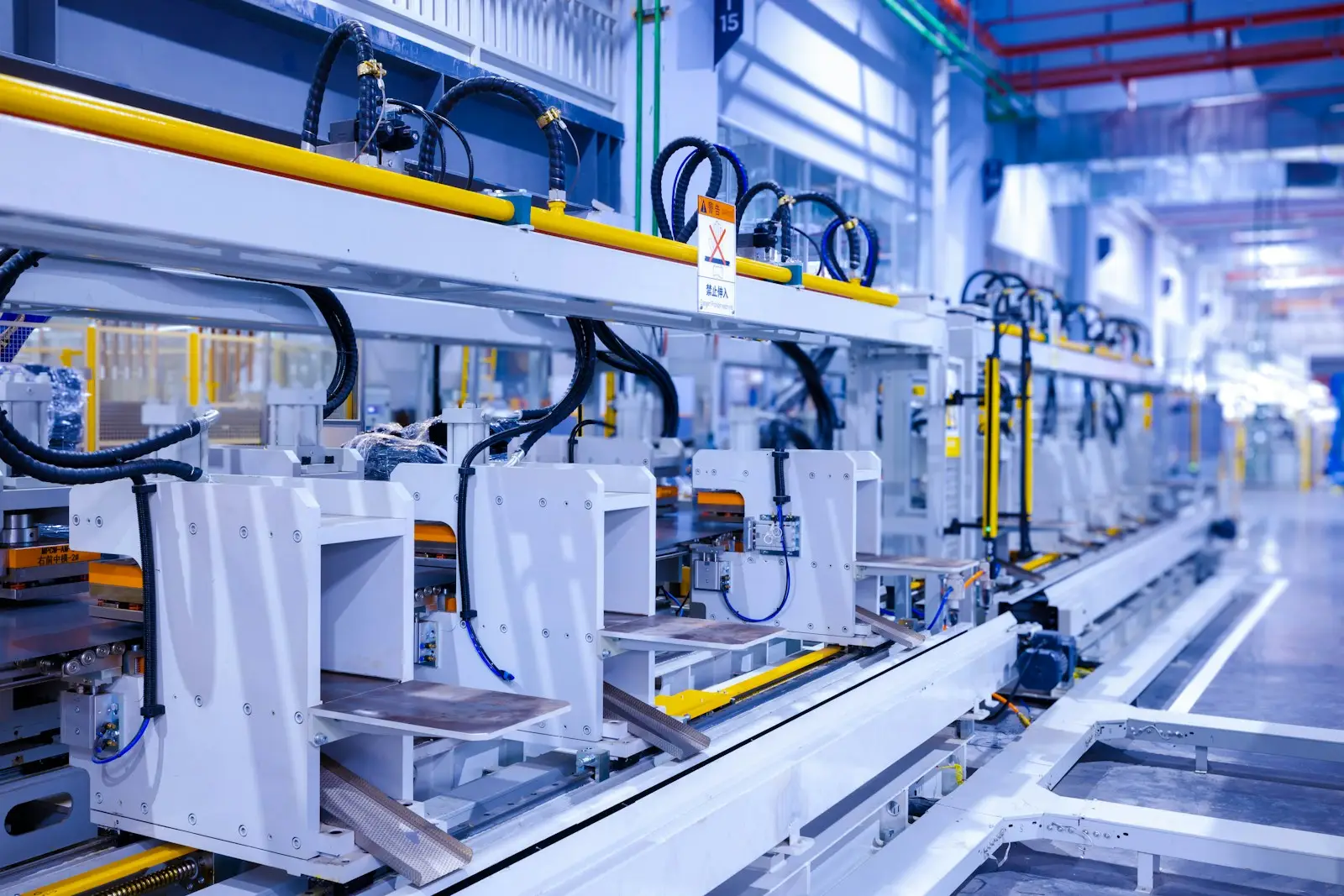 Robotic assembly stations along a production line in a factory hall