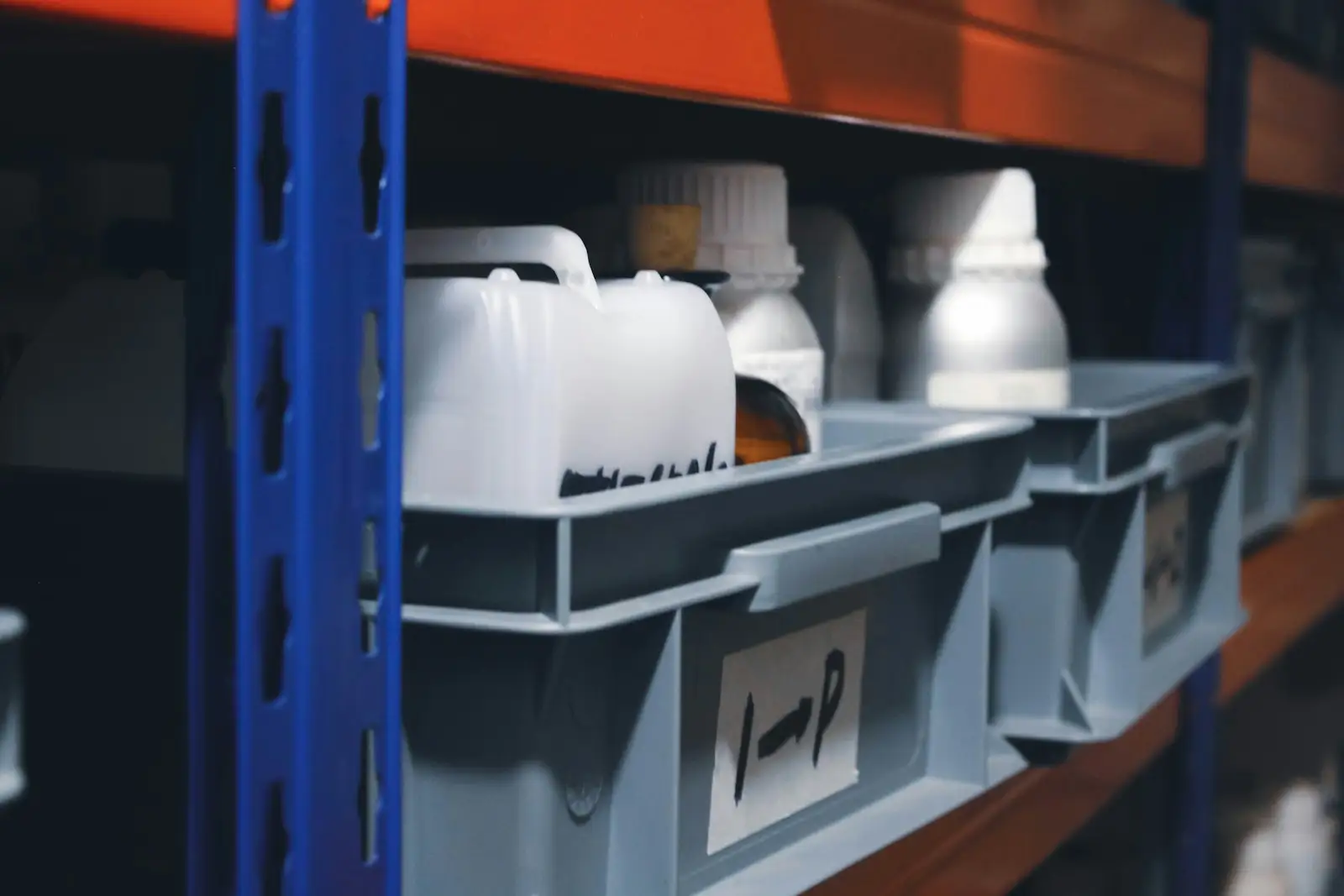 Labelled grey bins on industrial shelving