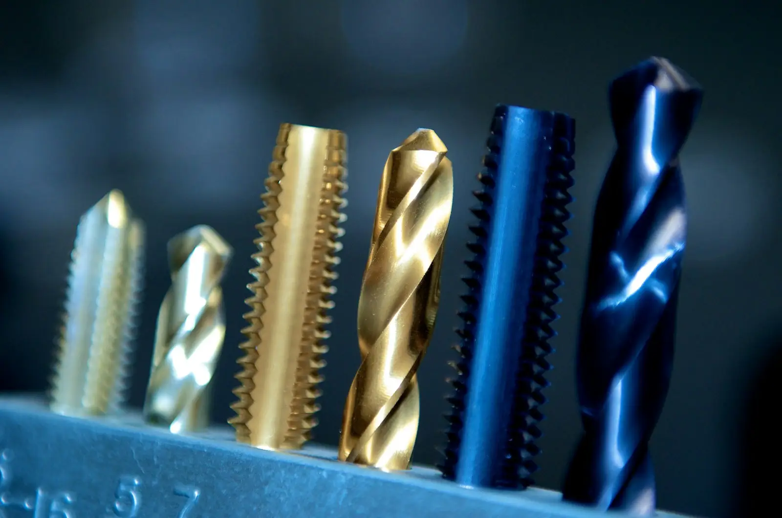 Precision taps and drill bits standing in a metal holder