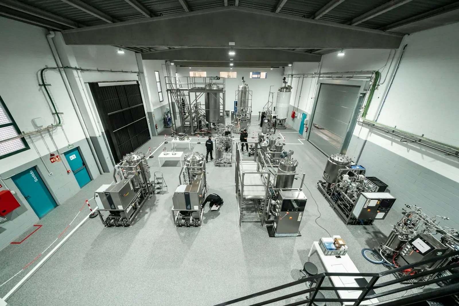 A bioprocess room with stainless steel tanks, bioreactors and filtration skids