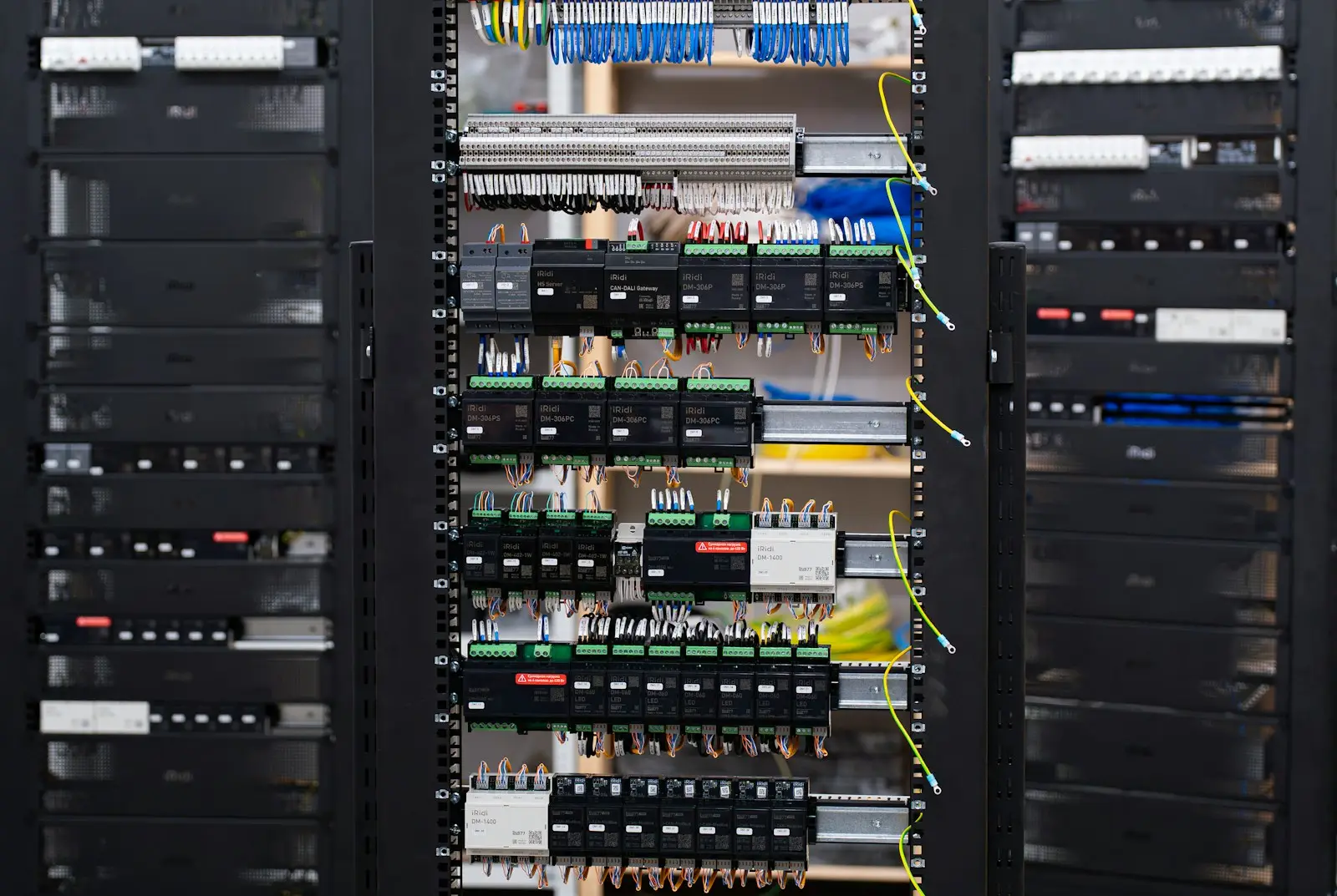 An open automation rack with DIN rail controller modules and dense wiring